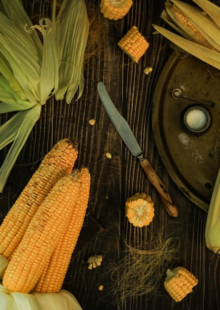 Reife Maiskolben auf einem Holztisch - Bio-Lebensmittel von oben, Gemüse in der globalen Erntekrise