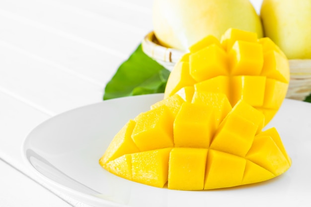 Reife Mango-Scheibe auf weißem Teller und weißem Boden