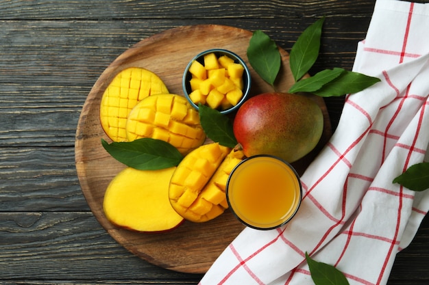 Reife Mangofrüchte und Saft auf Holztisch