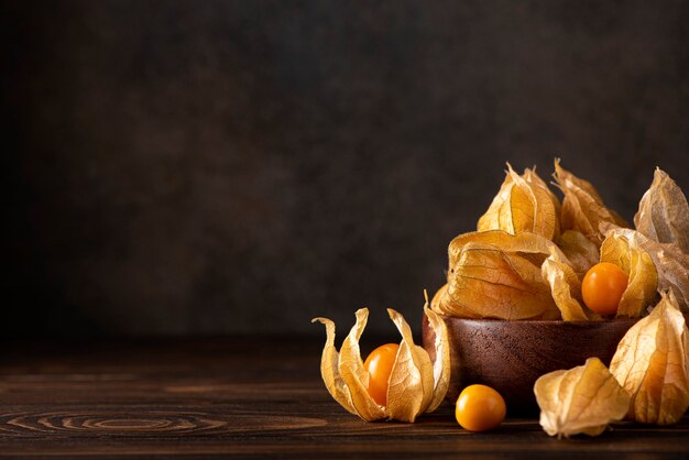 Reife orange physalis beeren auf einem holzbrett, nahaufnahme