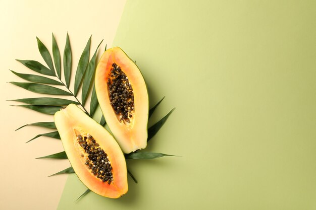 Reife Papaya mit Blättern auf zweifarbigem Hintergrund