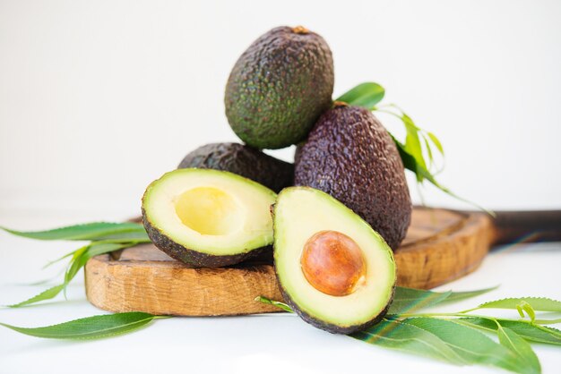 Reife reife Avocado Haas mit Blättern auf weißem Hintergrund, selektiver Fokus, Nahaufnahme close