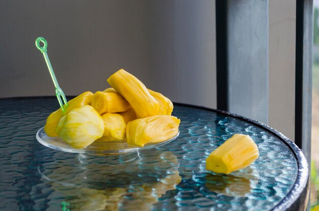 Reife, saftige, köstliche, leuchtend gelbe, geschälte Früchte der indischen Brotfrucht auf einem Glastisch