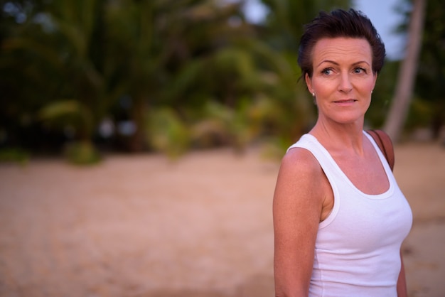 Reife schöne Touristenfrau, die am Strand entspannt