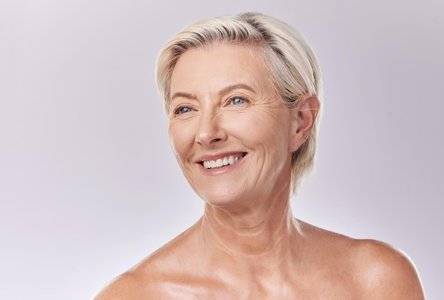 Reife Schönheit und Haut von Frauen, die in Hautpflege und Kosmetik mit Zähnen und Lächeln posieren Porträt eines glücklichen älteren Modells oder einer älteren Dame im Wellness mit gesunder Hautpflege in einem Studio