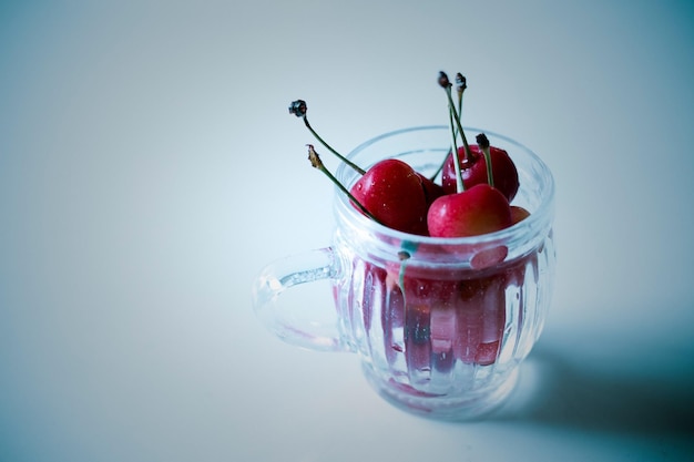 Reife Süßkirschen in einer Tasse auf grauem Hintergrund