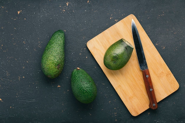 Reife und leckere Avocado-Früchte auf einem Schneidebrett mit einem Messer