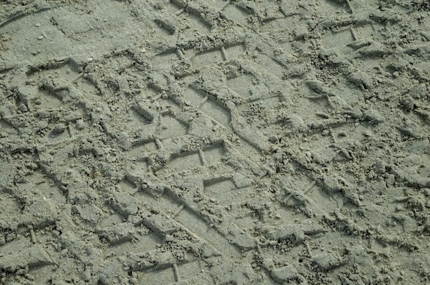 Reifen- oder Reifenspuren auf Sandstrandhintergrund