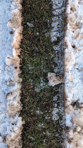 Reifenspur auf gefrorenem Gras im Schnee