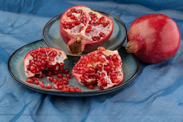 Reifer Granatapfel auf einem Tisch auf blauem Hintergrund