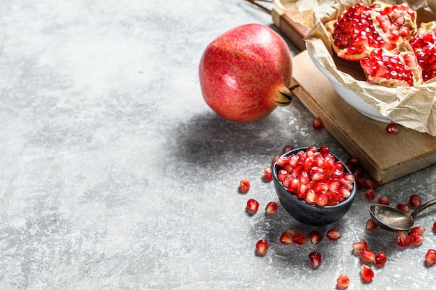 Reifer Granatapfel und Samen auf einem hölzernen Schneidebrett. Bio-Obst. Ansicht von oben.