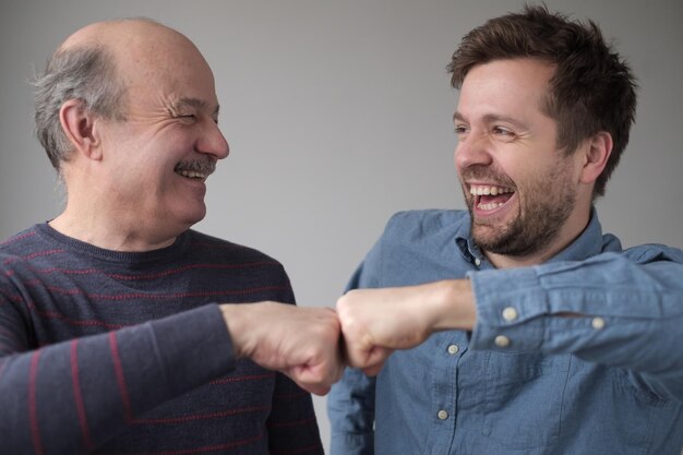 Foto reifer kaukasischer vater und sohn, die gemeinsam spaß haben und ihren erfolg feiern