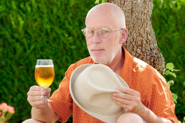 Reifer Mann, der draußen ein Bier trinkt