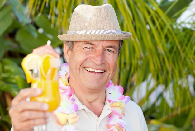 Foto reifer mann, der ein cocktail unter der sonne trinkt