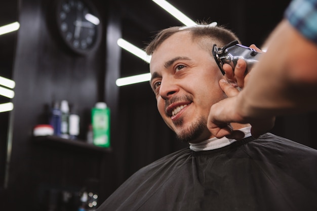 Reifer Mann, der einen neuen Haarschnitt am Friseursalon erhält