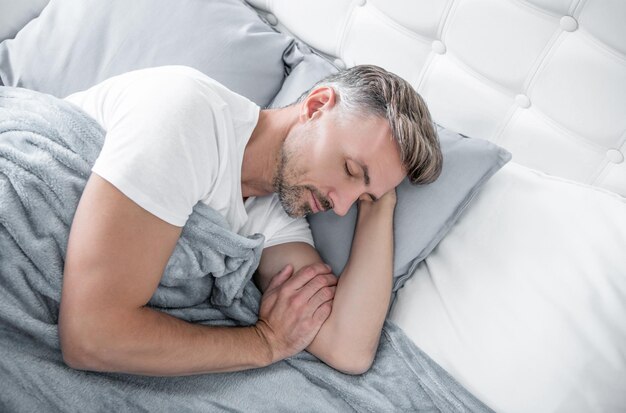 Foto reifer mann, der früh morgens im bett schläft