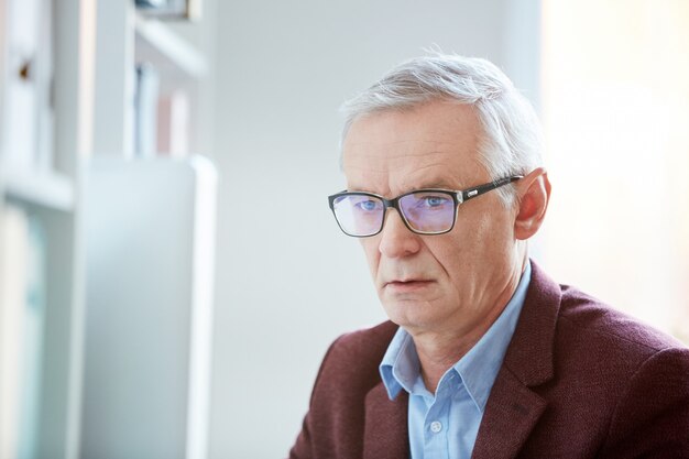 Reifer Mann, der im Büro arbeitet