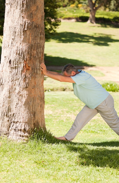 Reifer Mann, der seine streches im Park tut