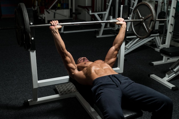 Reifer Mann im Fitnessstudio beim Bankdrücken