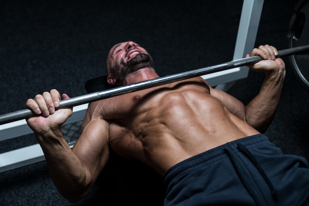 Reifer Mann im Fitnessstudio beim Bankdrücken