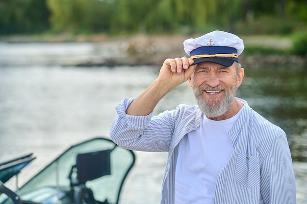 Foto reifer mann in kapitänsmütze sieht selbstbewusst aus