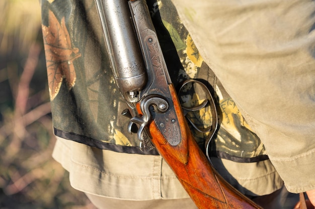 Reifer Mann Jäger mit Waffe beim Gehen auf dem Feld