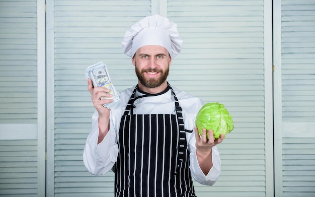 Reifer Mann liebt gesundes Bio-Essen Geld Business Profikoch Koch im Restaurant Küche Vegetarier Ernährung Vitamin kulinarische Küche Gemüse Transport Mann Kohl für Dollar kaufen