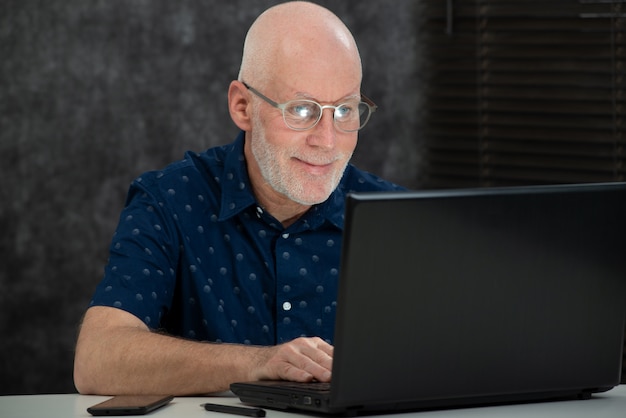 Reifer Mann mit Bart und blauem Hemd im Büro