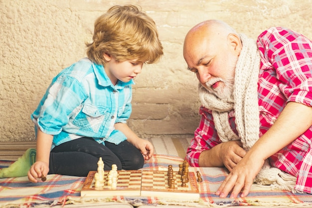 Reifer Mann mit dem kleinen Jungen, der Schach spielt