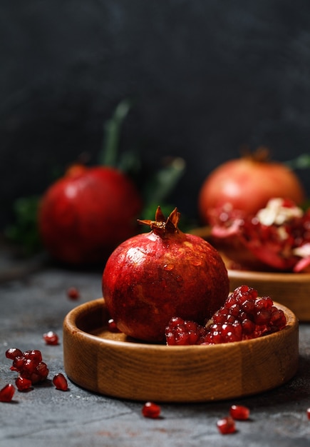 Reifer saftiger Granatapfel auf grauem Hintergrund Lebensmittelhintergrund