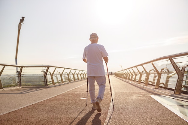 Reifer Sportler übt Nordic Walking auf leerem Steg