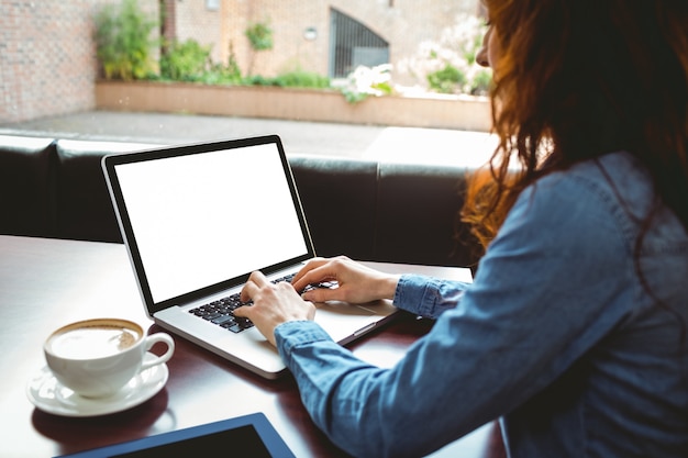 Reifer Student, der Laptop im Café verwendet