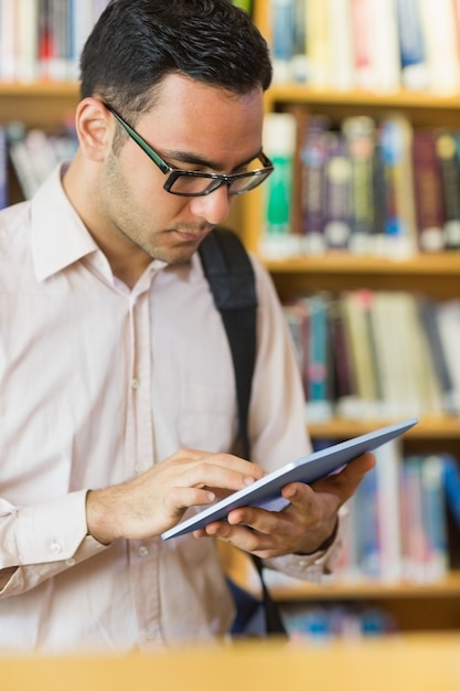 Reifer Student, der Tablet-PC in der Bibliothek verwendet