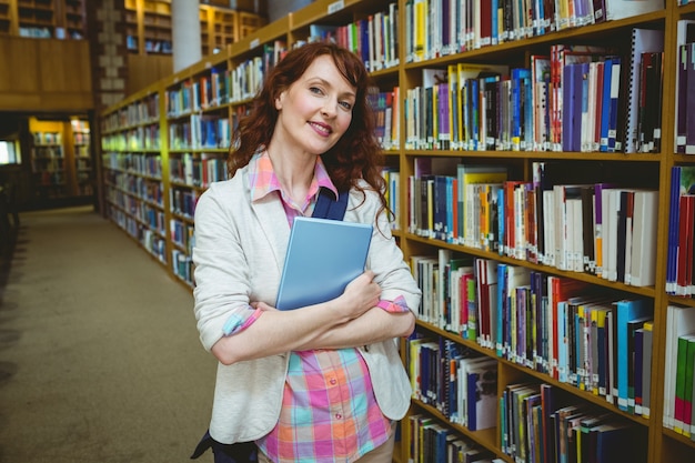 Reifer Student in der Bibliothek unter Verwendung der Tablette