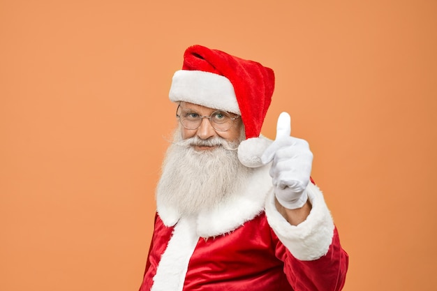 Reifer Weihnachtsmann in traditioneller Tracht mit echtem grauem Bart und Brille mit Daumen nach oben