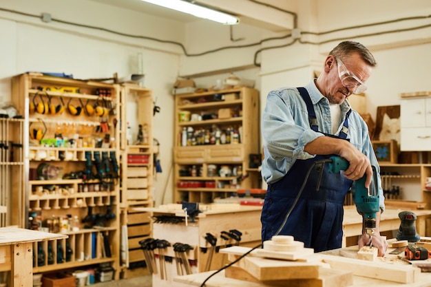 Reifer Zimmermann, der Holz bohrt