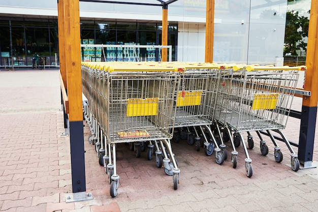 Reihe leerer Einkaufswagen in der Nähe eines Ladens, Nahaufnahme