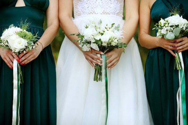 Reihe von Brautjungfern mit Blumensträußen bei der Hochzeitszeremonie