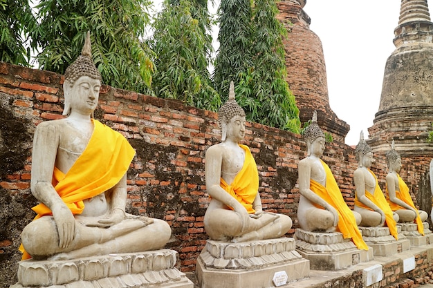 Reihe von Buddha-Bildern mit einer Gruppe von Stupas Wat Yai Chai Mongkhon Tempel Ayutthaya Thailand