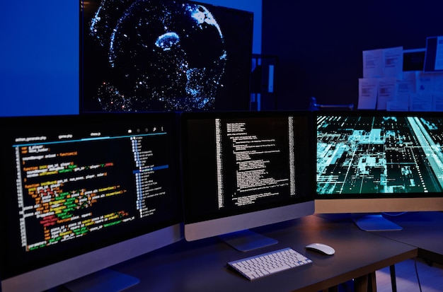 Reihe von drei Computermonitoren mit codierten Daten auf Bildschirmen
