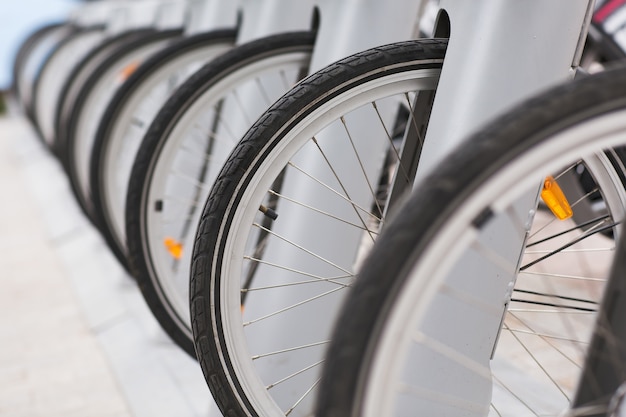 Reihe von geparkten Weinlesefahrrädern fährt für Miete auf Bürgersteig rad