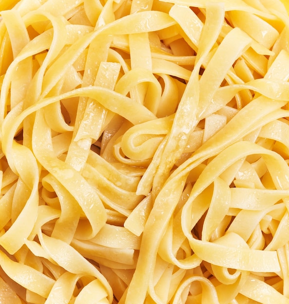 Reihe von italienischen Tagliatelle-Nudeln auf gelbem Hintergrund