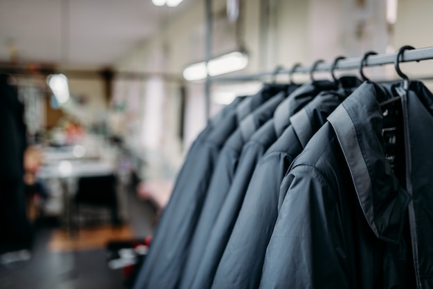 Reihe von Jacken auf Kleiderbügeln, Bekleidungsgeschäft, Stoff