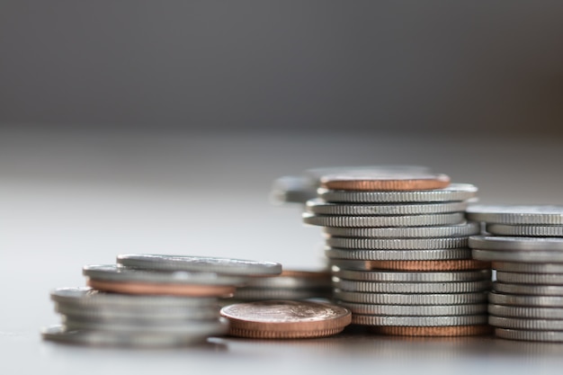 Reihe von Münzen auf hölzernem Hintergrund für Finanz- und Einsparungskonzept, Investition, Wirtschaft, Weichzeichnung