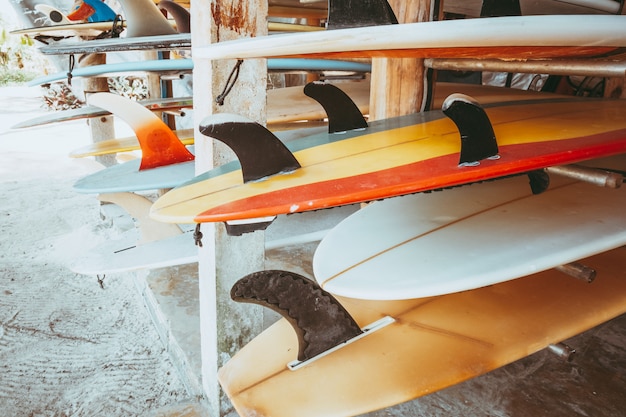 Reihe von verschiedenen bunten Surfbretter in einem Stapel zur Miete am Strand.