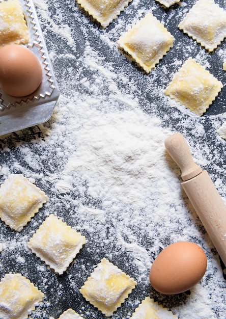 Reihen der rohen selbst gemachten Ravioli mit Bestandteilen, Abschluss hoch und Draufsicht