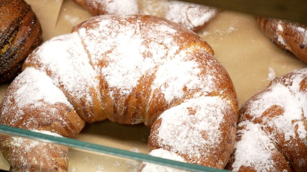 Reihen warmer, frisch gebackener Brötchen, die im Bäckereistand im örtlichen Lebensmittelgeschäft ausgestellt sind