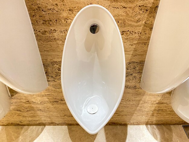 Reinigen Sie das männliche Urinal in der Toilette