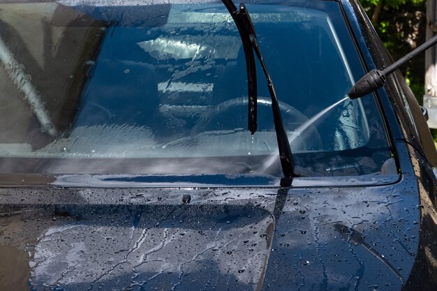 Reinigung des Autos mit Hochdruckwasserspray im Hinterhof.