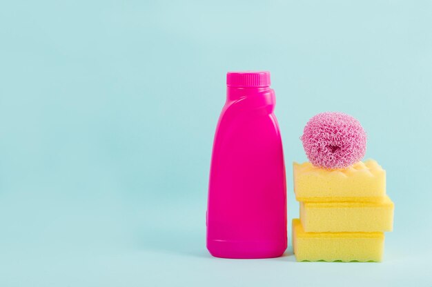 Reinigung rosa Lieferungen Sammlung auf blauem Hintergrund Hausarbeit Konzept Rosa Flasche mit Waschmittel